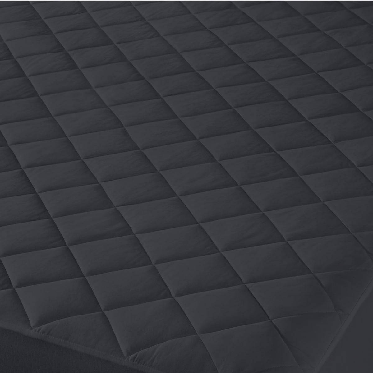 Close-up of a quilted mattress cover with a diamond pattern.