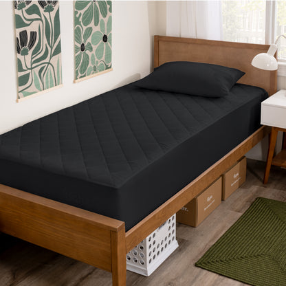 Wooden bed with black mattress cover in a room with decorative elements.