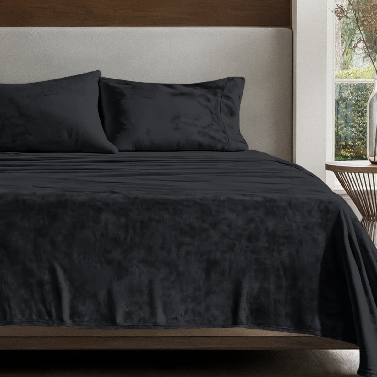 Microplush sheet set on a bed in a bedroom setting with a nightstand and lamp.