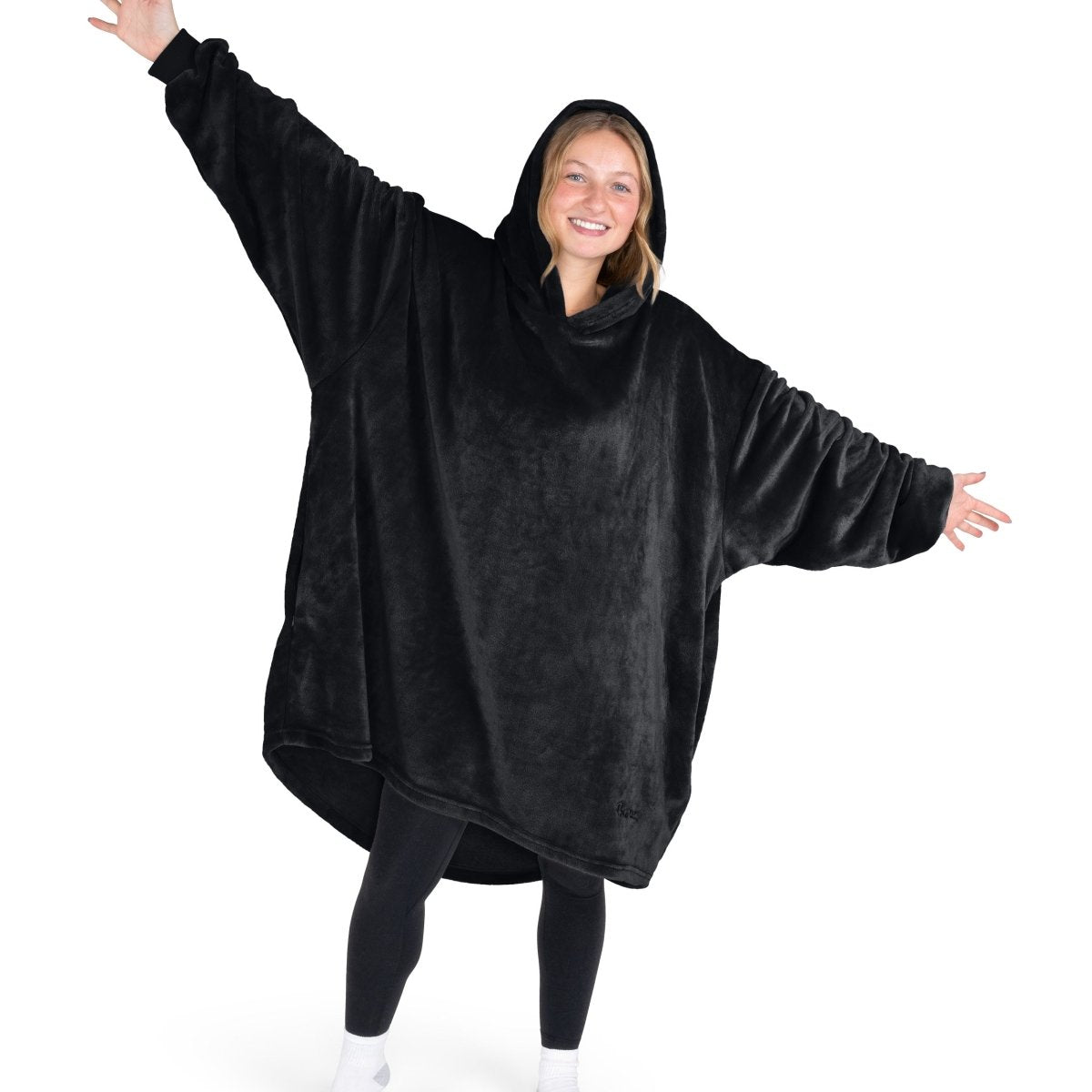 A woman wearing a hooded blanket made of microplush, showcasing comfort and warmth