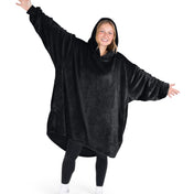 A woman wearing a hooded blanket made of microplush, showcasing comfort and warmth