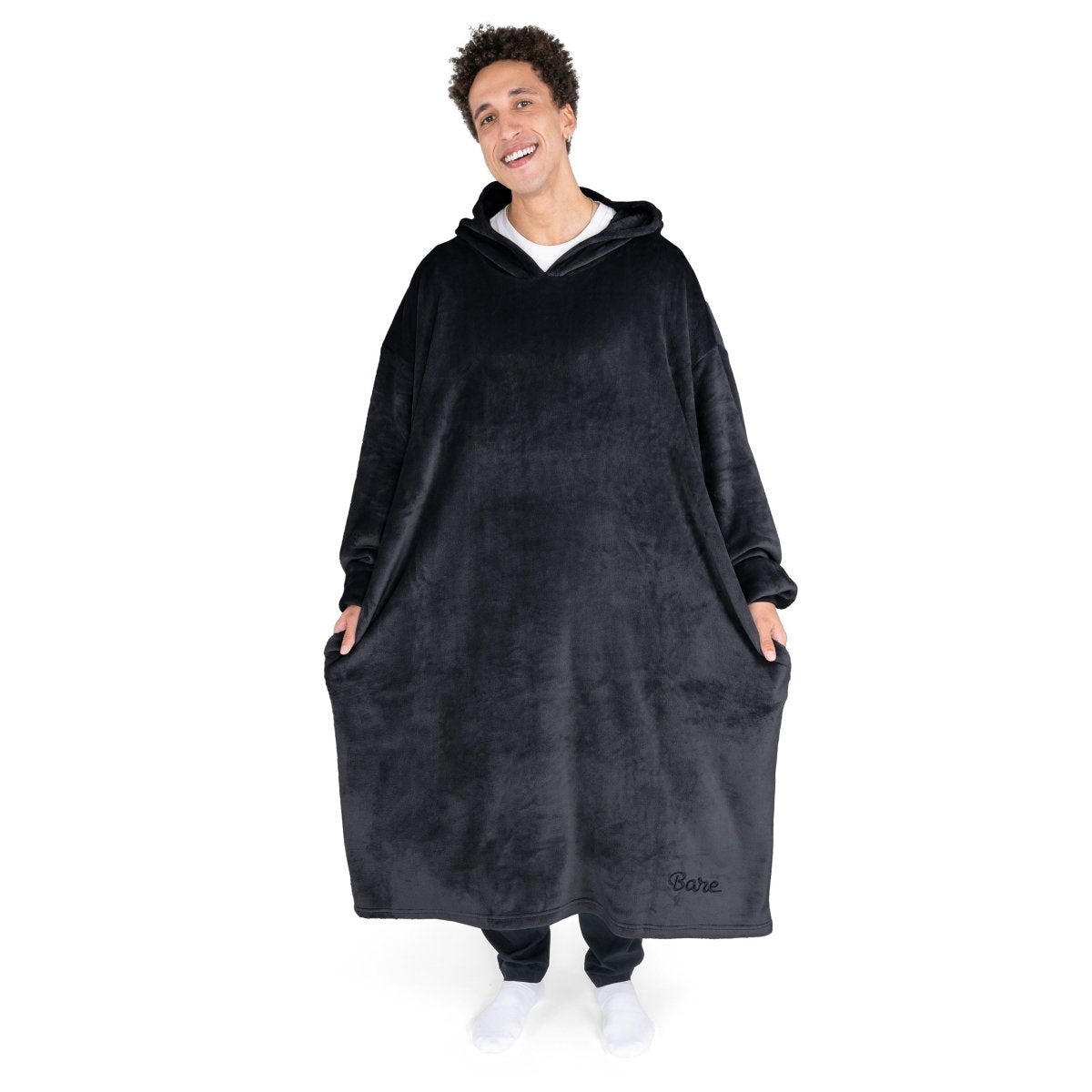 An adult with long microplush wearable blanket on