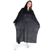 An adult is standing while wearing a long microplush wearable blanket
