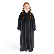 A girl is standing while wearing a long microplush wearable blanket
