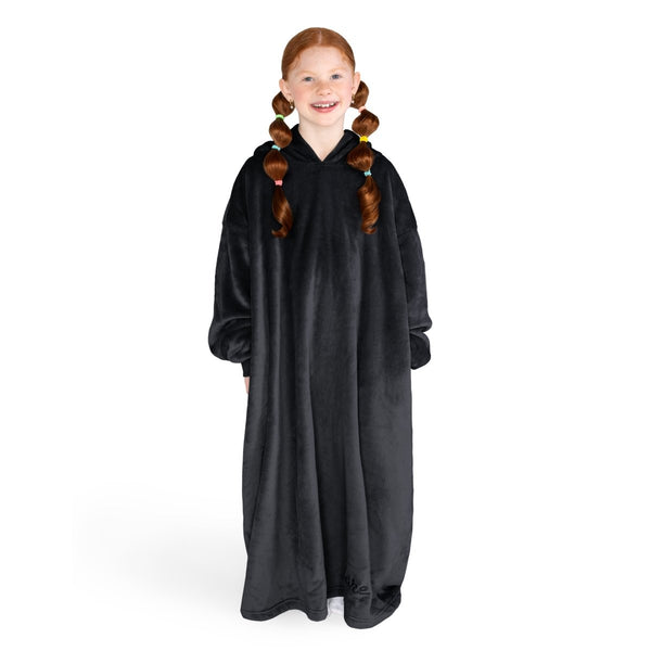 A girl is standing while wearing a long microplush wearable blanket