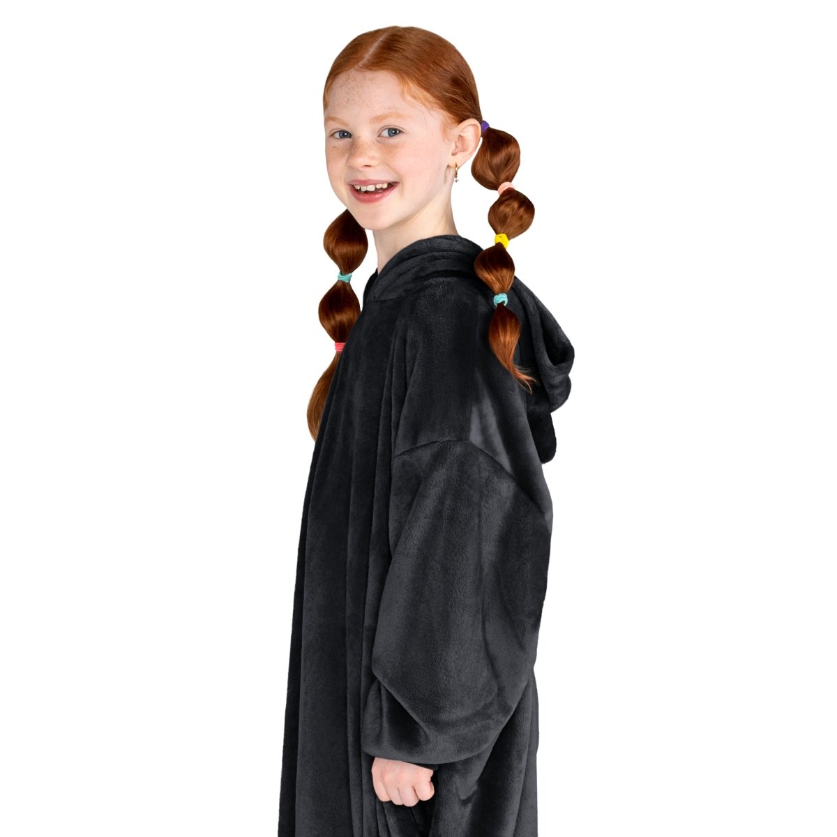 A girl has a microplush wearable blanket on