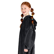 A girl has a microplush wearable blanket on
