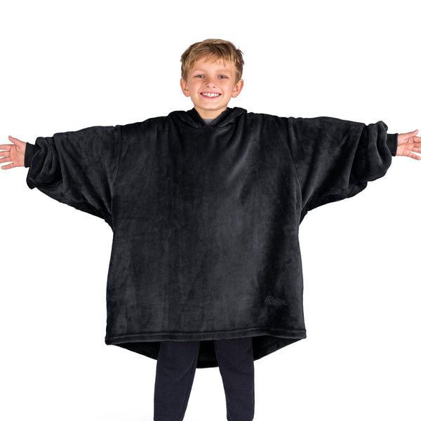 A boy wearing a blanket made of microplush, showcasing comfort and warmth.