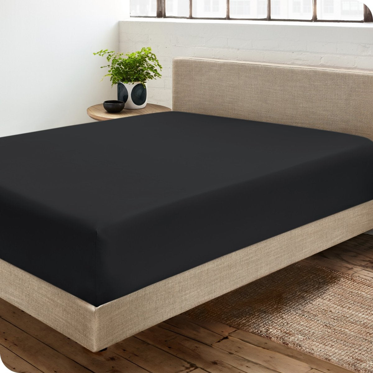 Diagonal view of modern bedroom with a sateen fitted sheet on the bed