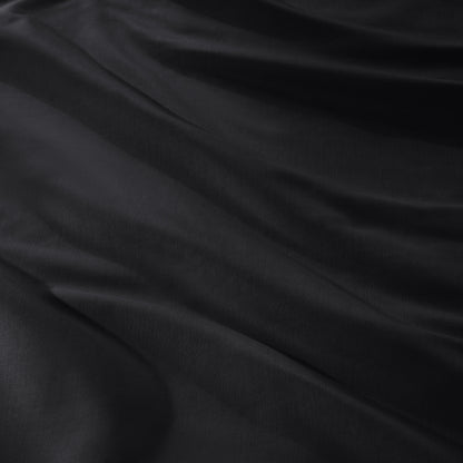 A close-up of draped sateen fabric with soft folds and a smooth texture.