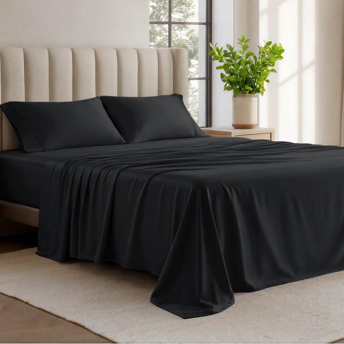 Organic cotton jersey sheets on a bed with a wicker headboard in a room with plants and a lamp.