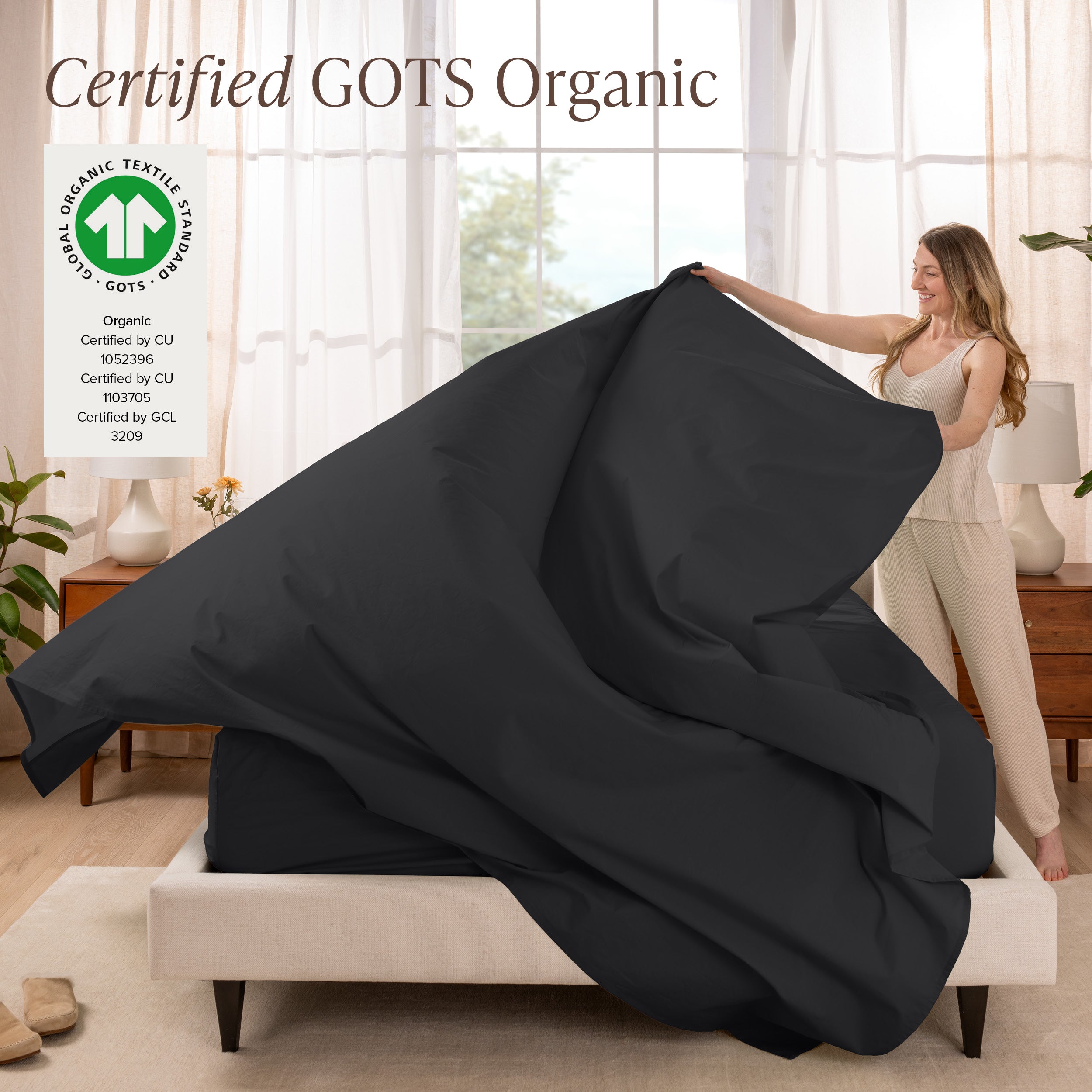 A woman is making a bed with organic cotton percale sheets