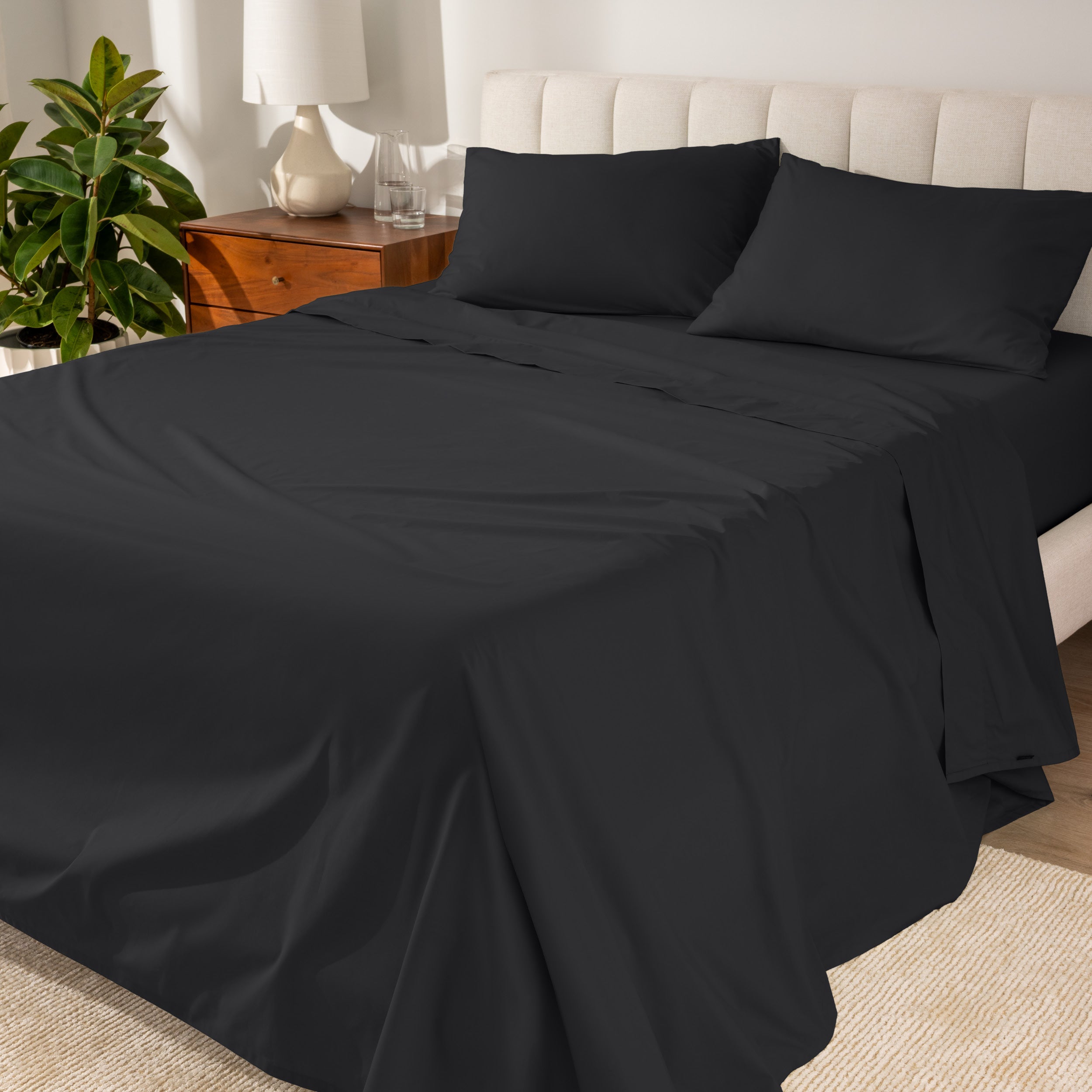 Percale sheets on a bed with a cream colored frame and headboard