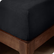 A corner of a modern bed with a polar fleece fitted sheet on.