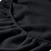 A close view of the elastic of a polar fleece fitted sheet.