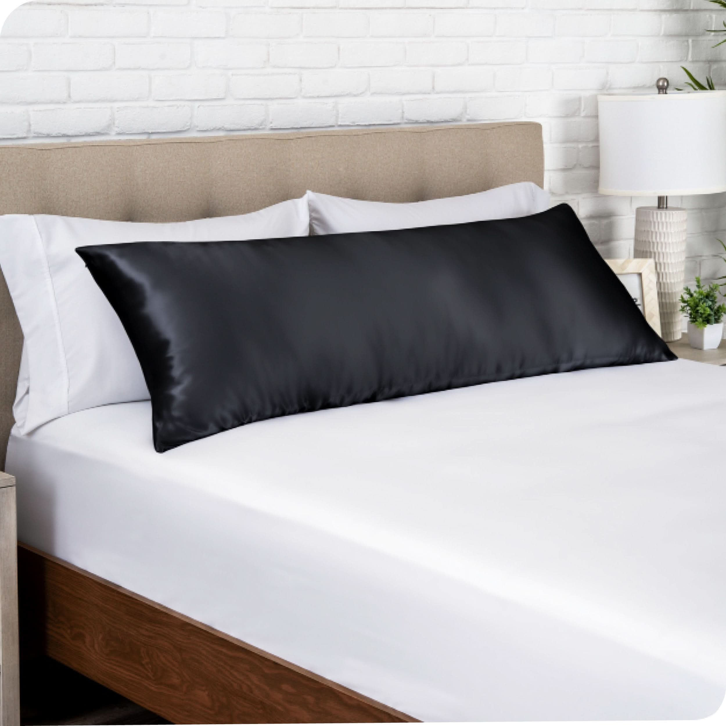 A satin body pillowcase on a bed with white linens