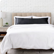 A satin body pillowcase on a bed with white linens