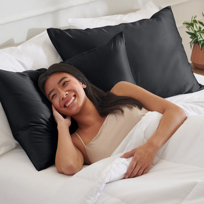 Woman lying on a bed with satin pillows and white bedding