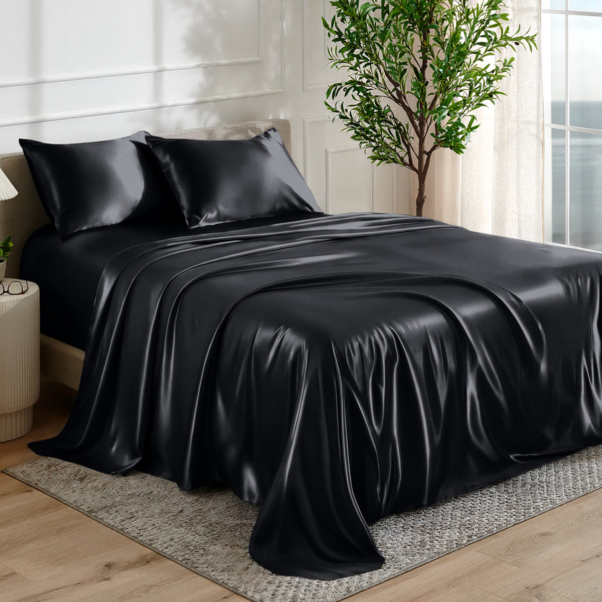 Satin sheet set on a bed in a bedroom with a plant and window in the background.