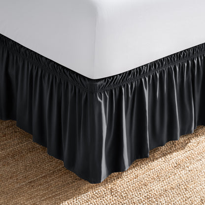 Bed with white fitted sheet and an adjustable bed skirt.