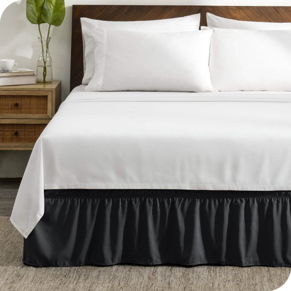 A wrap around bed skirt on a mattress with white bedding