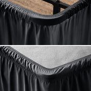 Close up of a polyester wrap around bed skirt on a bed frame and box spring