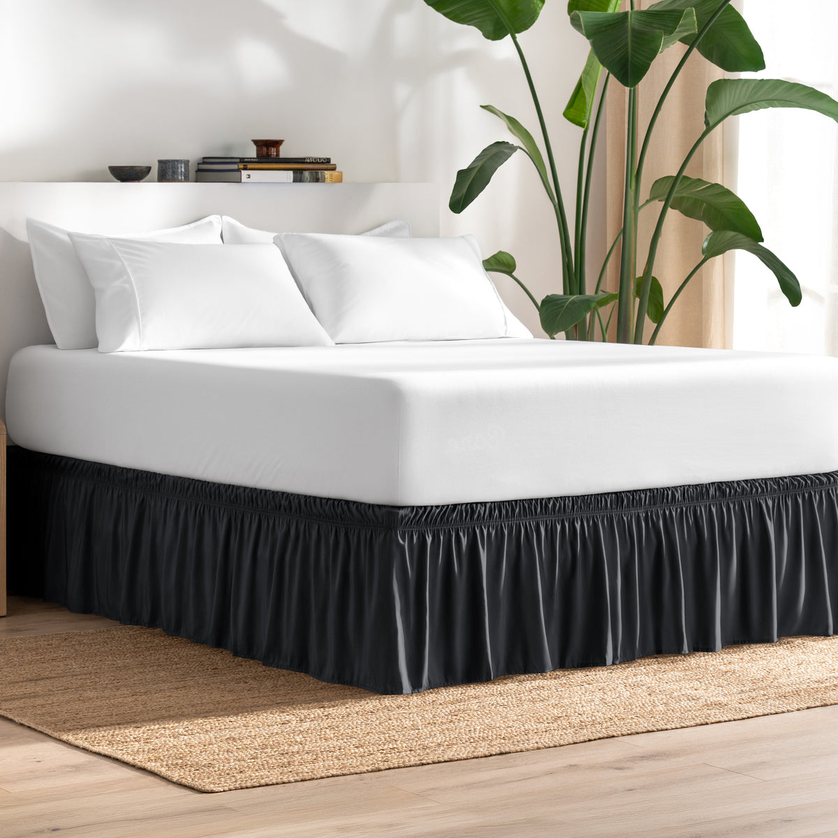 Bed with bed skirt, white bedding, and a plant in a room.