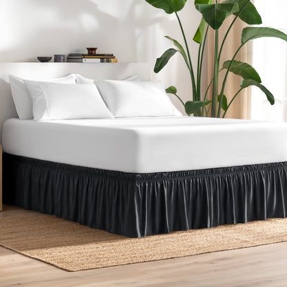 Bed with bed skirt, white bedding, and a plant in a room.