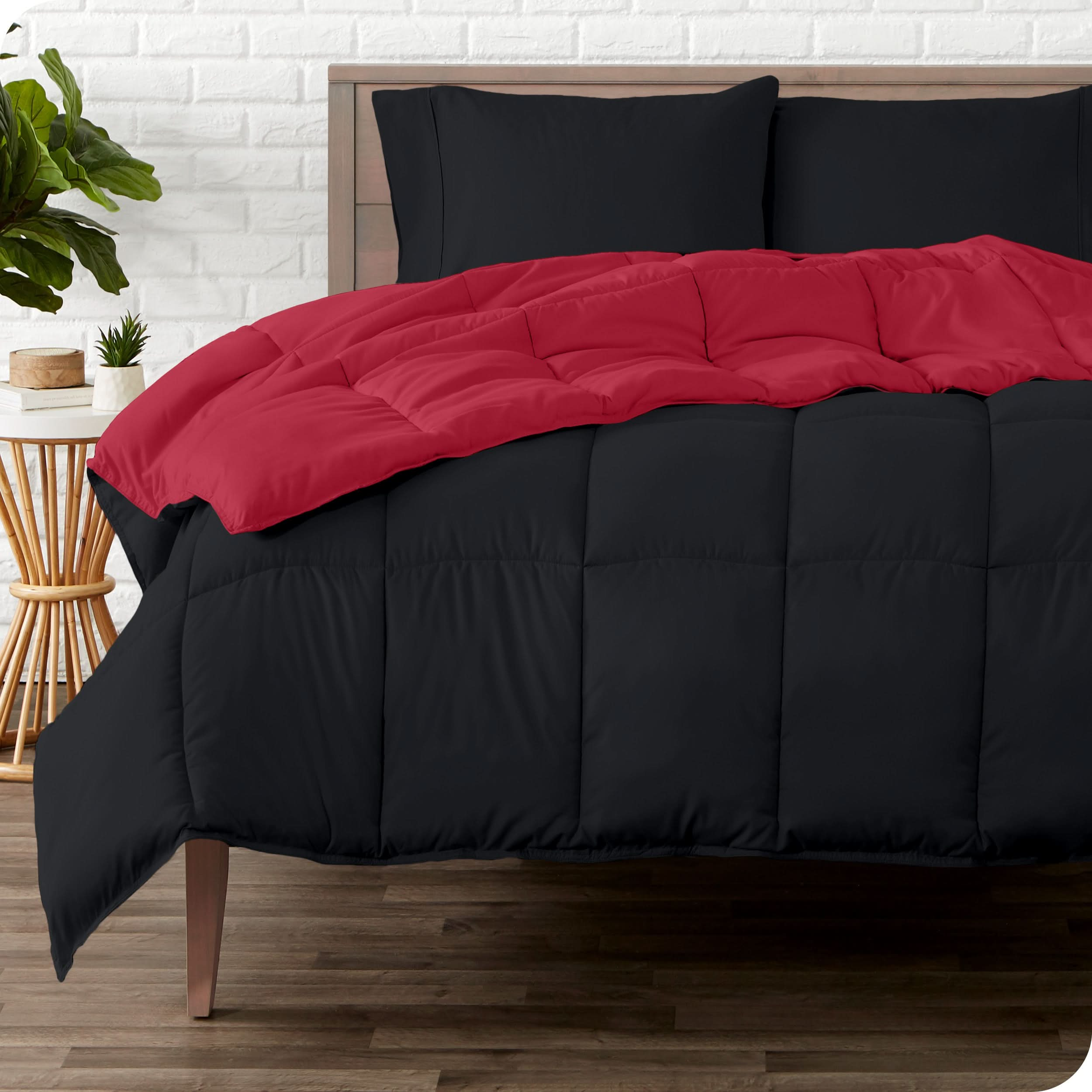 A wooden bed frame with a reversible comforter and sheet set on the mattress