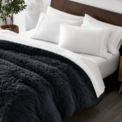 Shaggy duvet cover on a bed with white pillows and a wooden headboard.