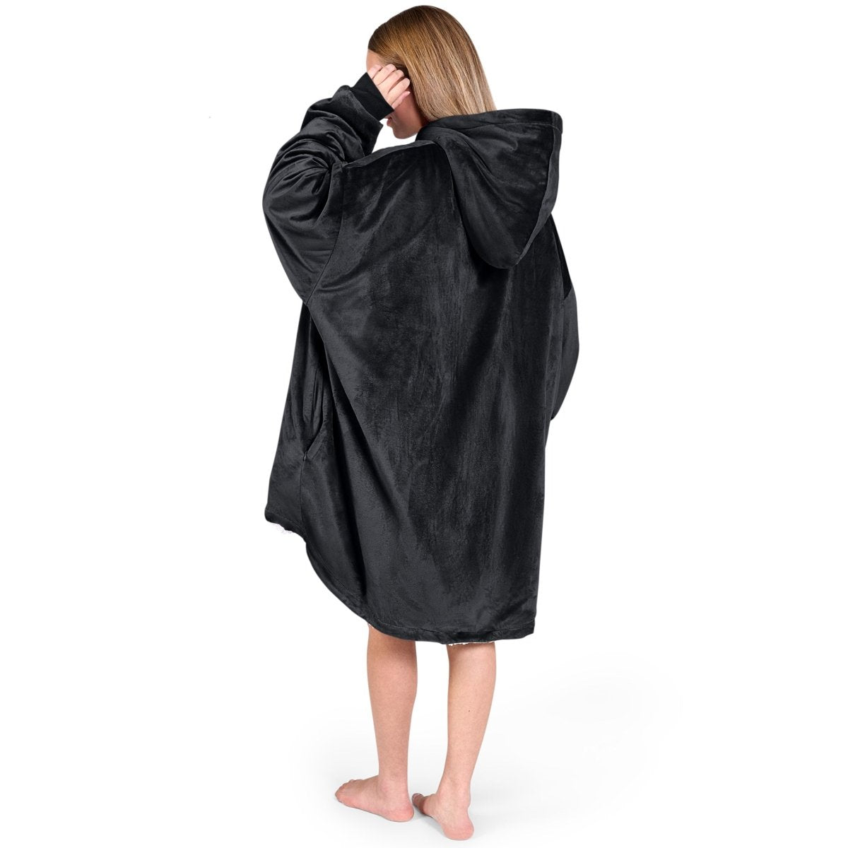 An adult with a sherpa wearable blanket on