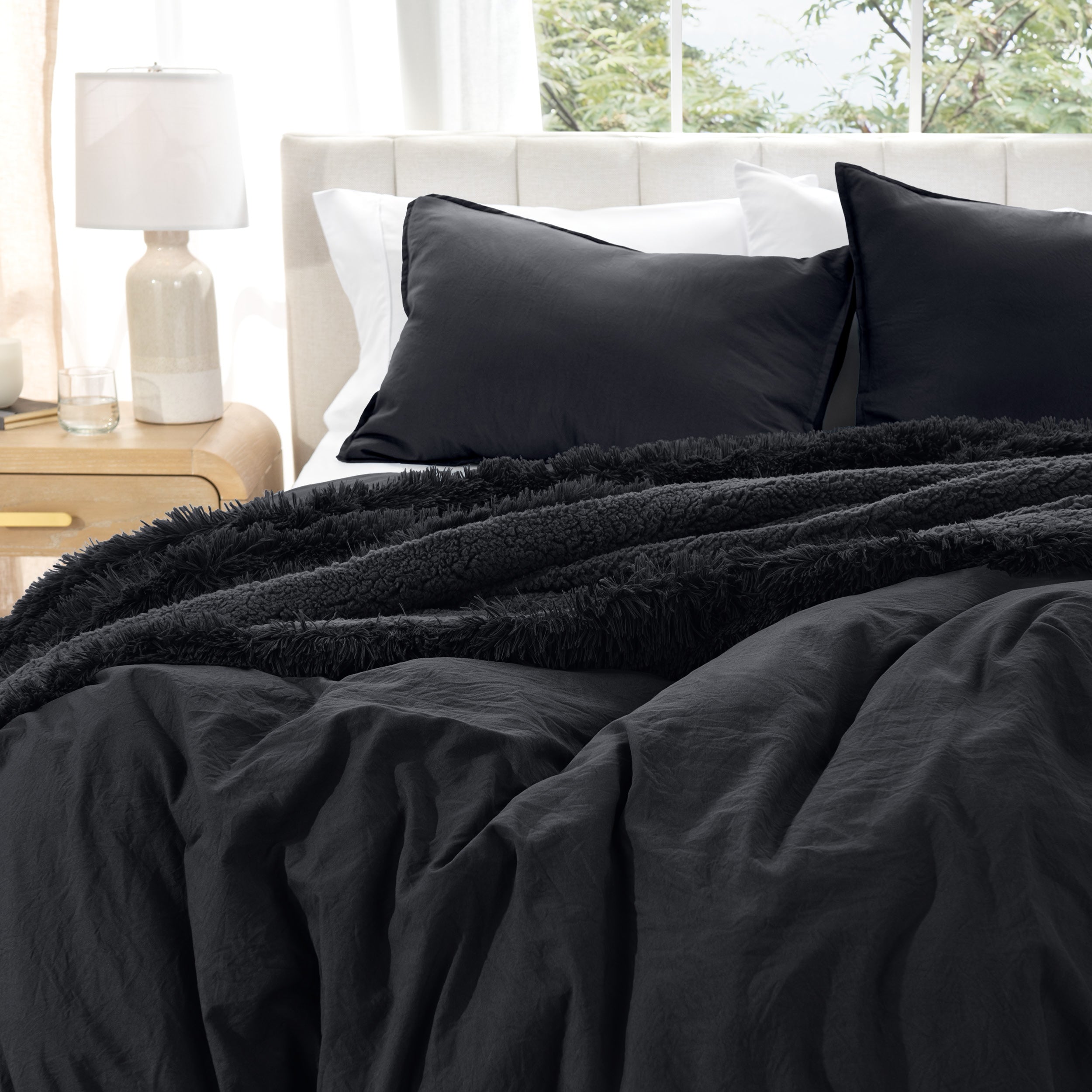 Washed duvet cover set on a bed with pillows and a lamp in the background