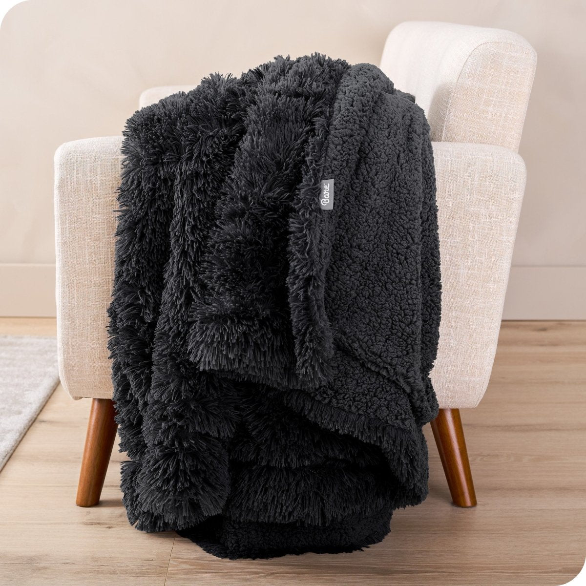 A shaggy faux fur blanket draped over the arm of a chair