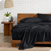 Microfiber sheets on a bed with a wooden headboard