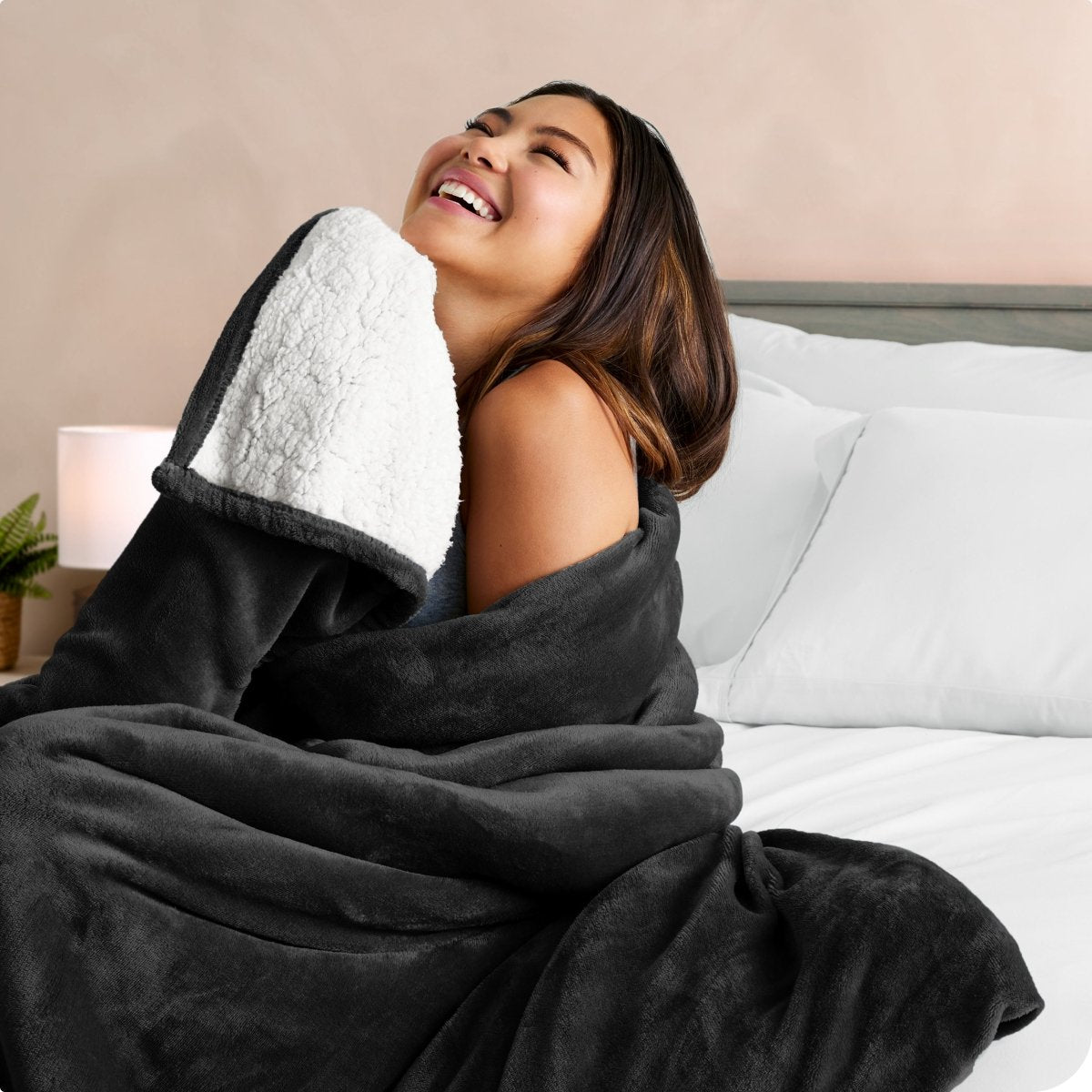 A woman smiling while wrapped in a sherpa blanket