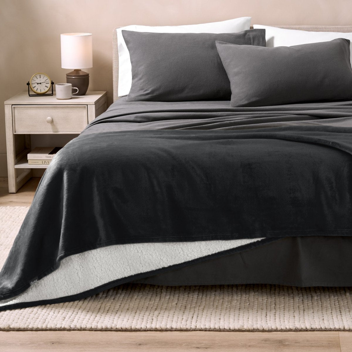 Bed with grey sheets and a sherpa blanket