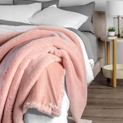 Blanket with 'Bare' branding on a bed in a bedroom setting
