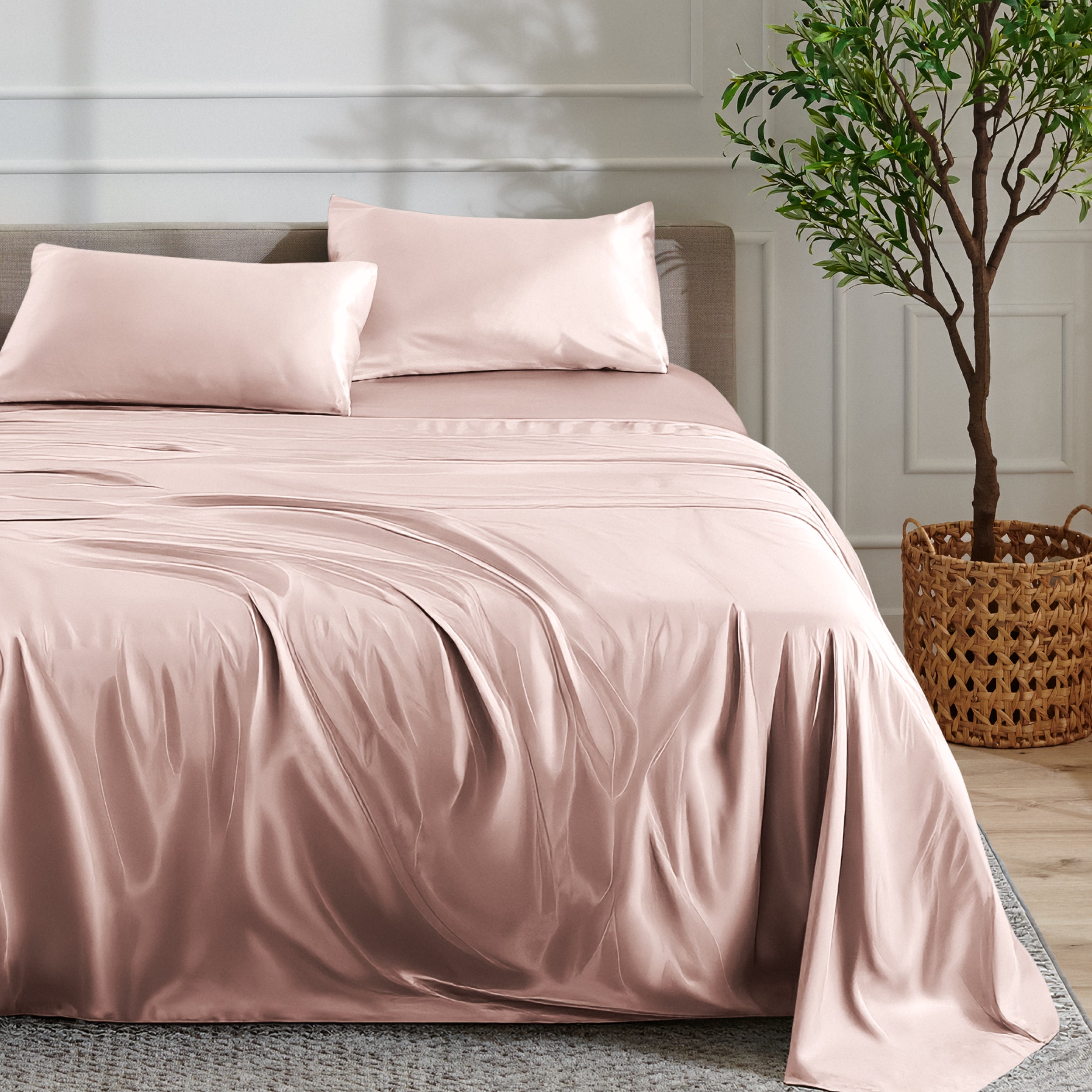 Satin sheet set on a bed with a plant and basket in the background