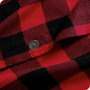 Close-up of red and black plaid duvet cover with a button.