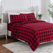 A bed made with printed flannel sheets