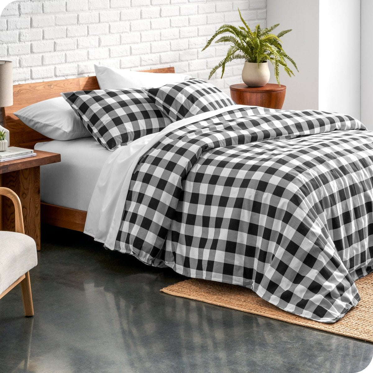 Bed with black and white checkered bedding in a modern bedroom setting.