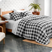 Bed with black and white checkered bedding in a modern bedroom setting.