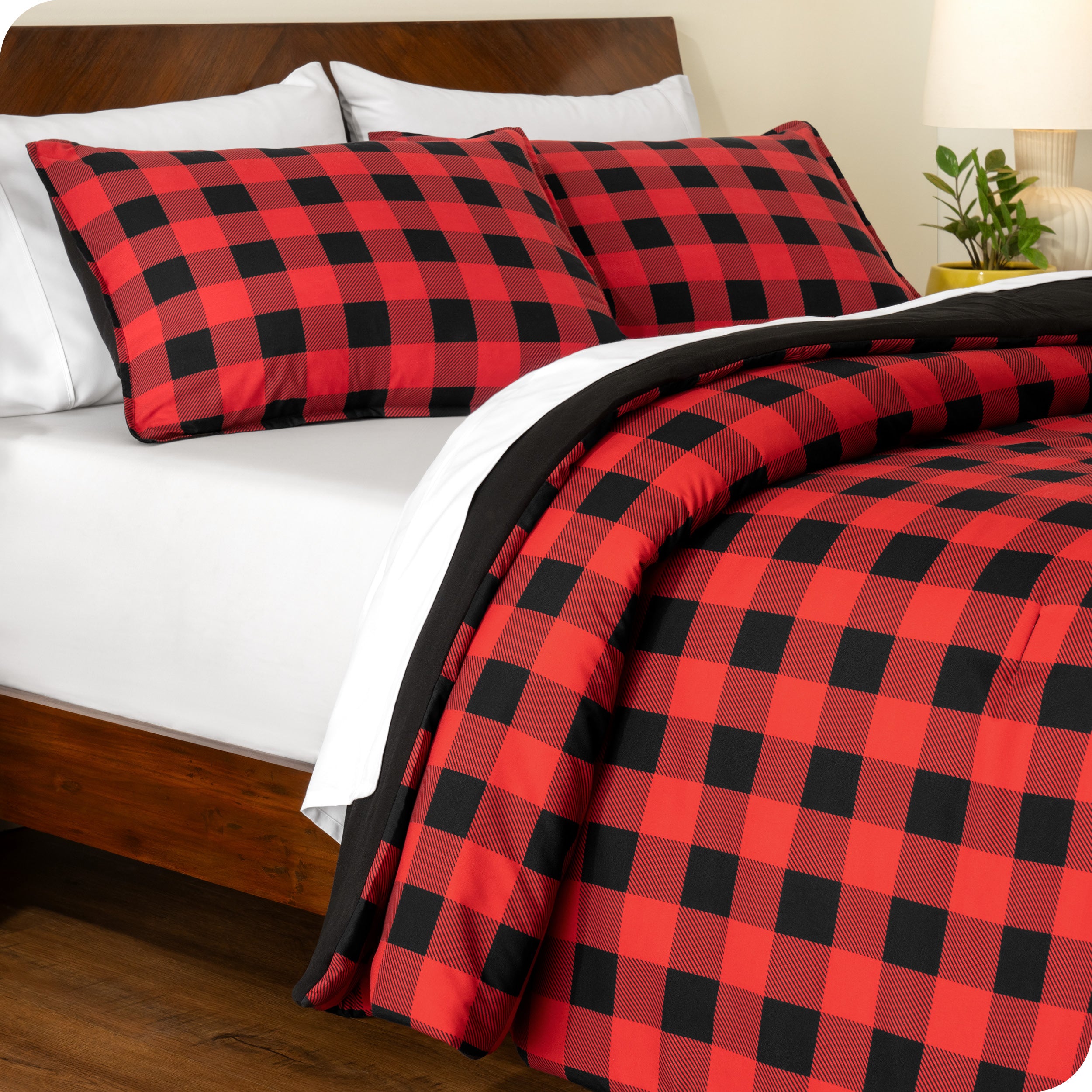 A side view of a printed comforter on a bed with a wooden frame and headboard