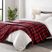 Red and black checkered blanket on a bed in a bedroom setting
