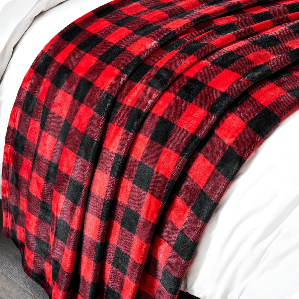 Red and black checkered blanket draped over a white surface