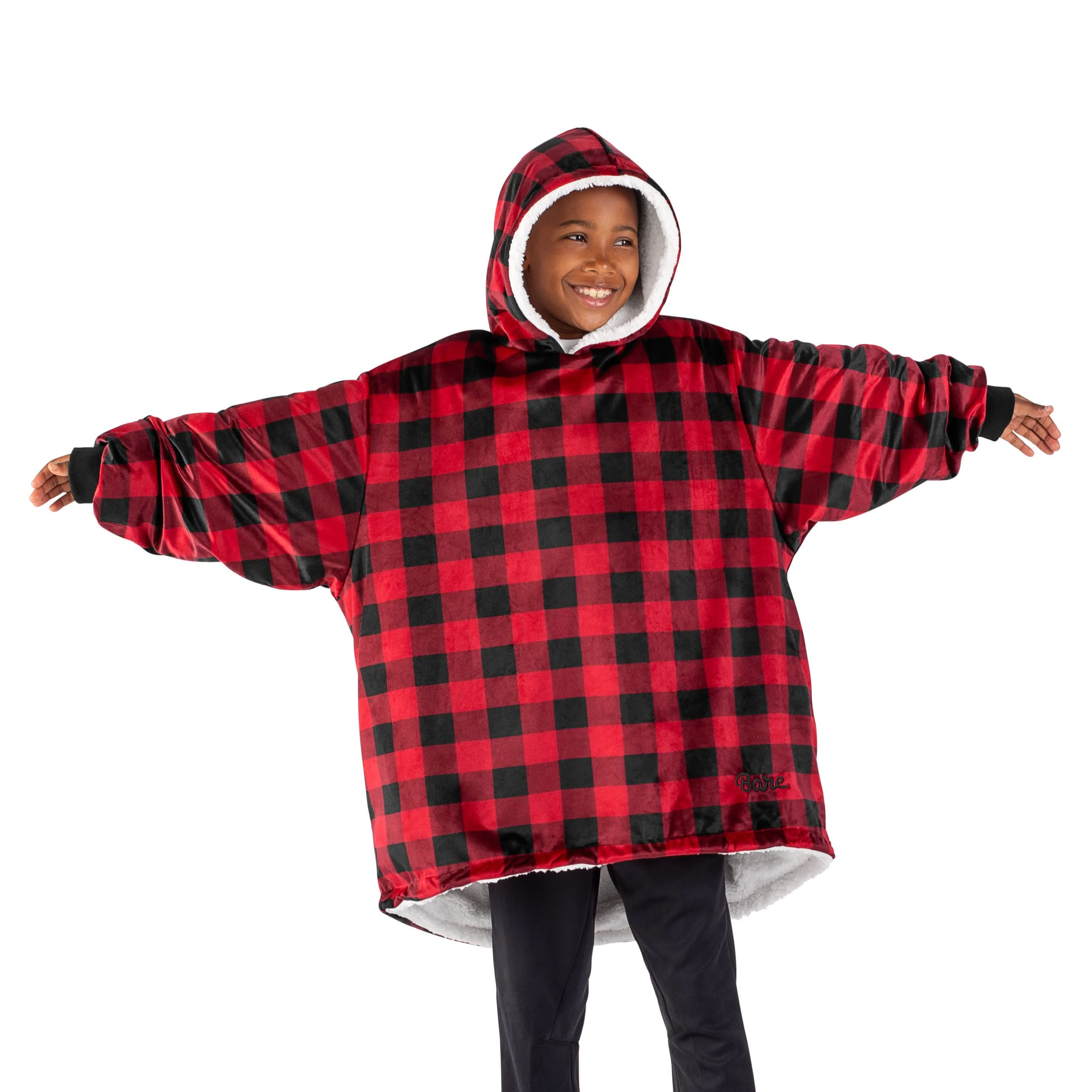 A boy standing with a wearable blanket on