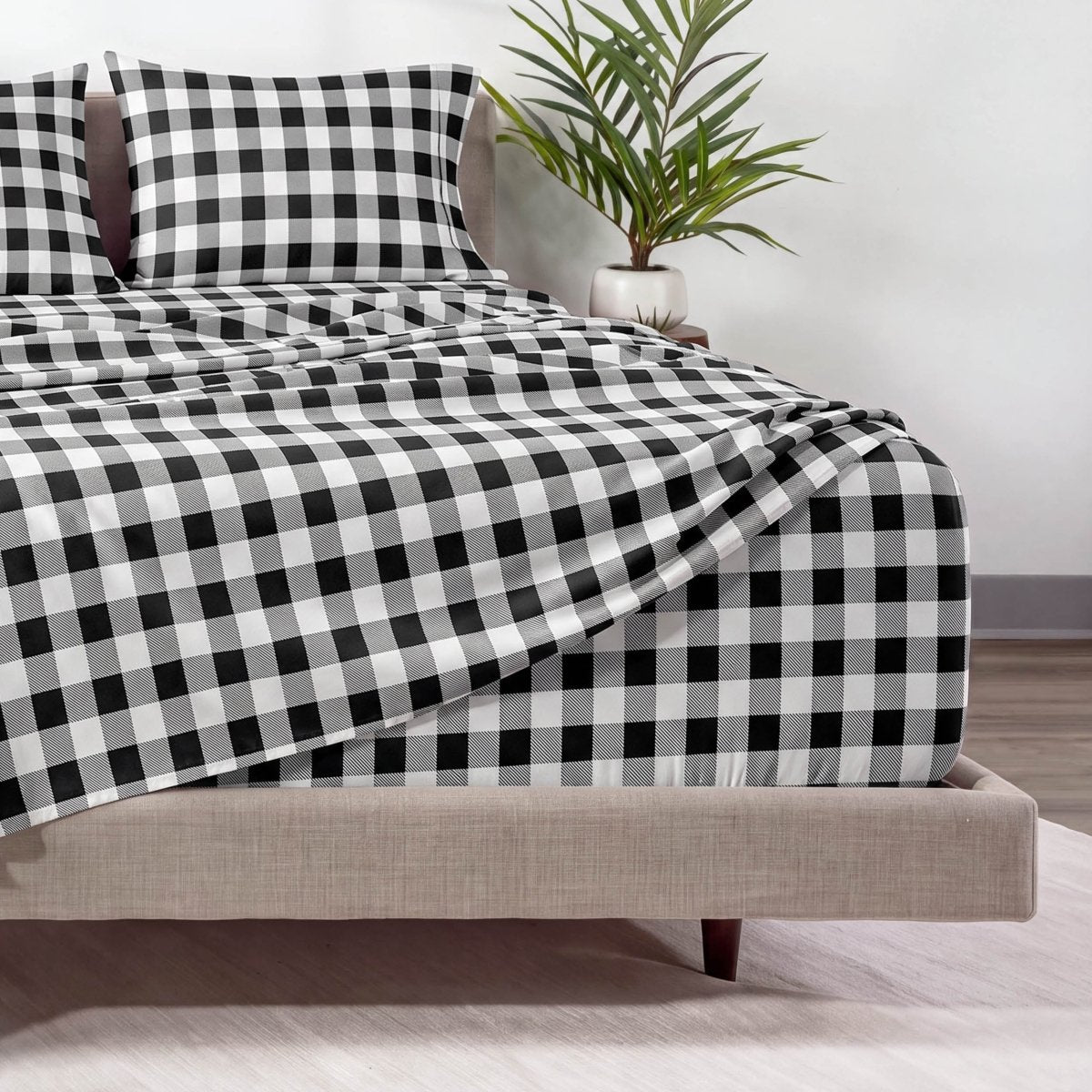 The corner of a bed with a printed fitted and matching top sheet