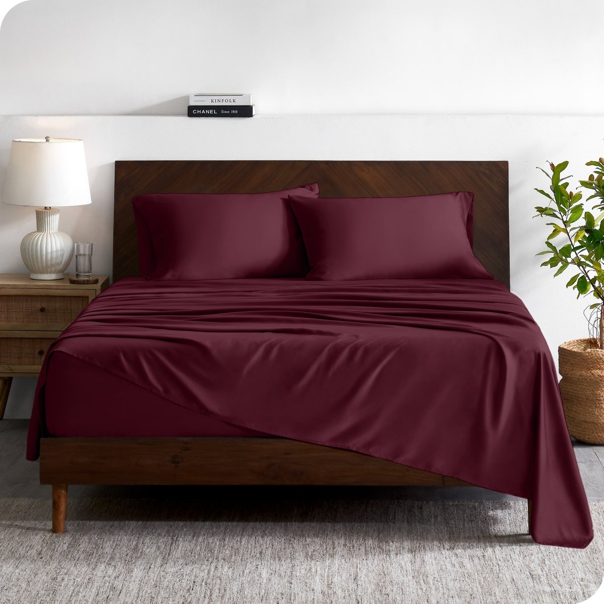 A contemporary bed with a sheet set and a wooden headboard.