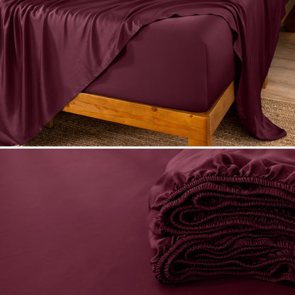 A fitted sheet on a mattress with wooden bed frame and folded on a dark surface