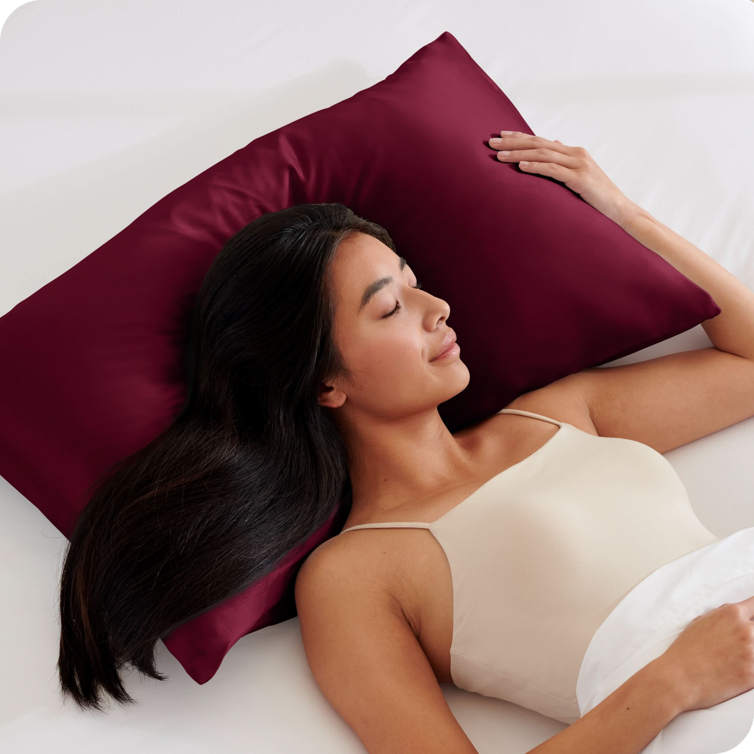 A woman is sleeping with her head on a silk pillowcase